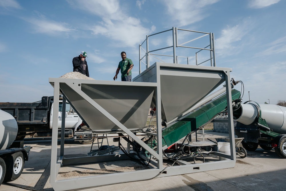 Men offering concrete service in Katy, mixing concrete at a construsctio site.